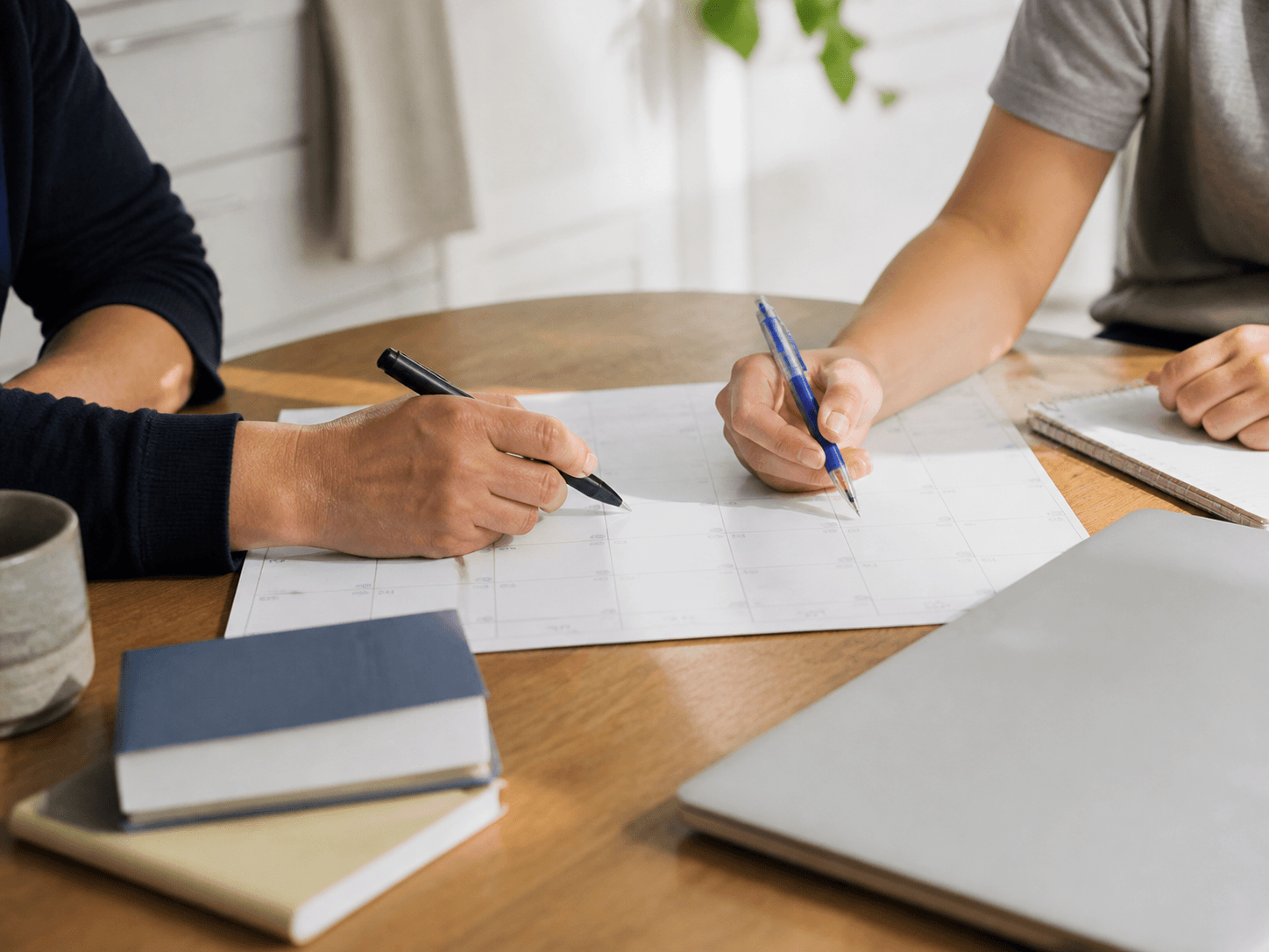 A parent and student planning a school week together at a table